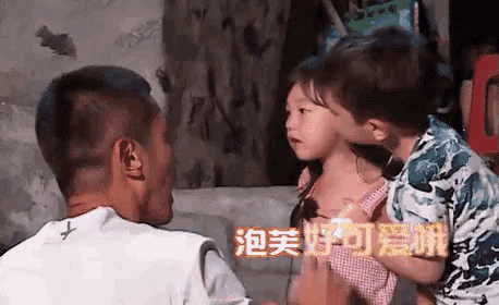 a man is holding a little girl in his arms and the little girl is kissing him on the cheek .