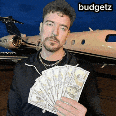 a man holding a bunch of money in front of a plane with the word budgetz on the bottom