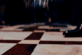 a crown is sitting on a checkered floor in a dark room
