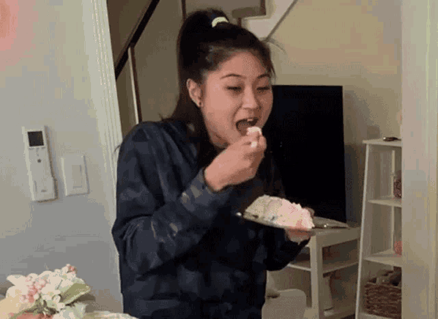 a woman is eating a slice of cake from a plate .