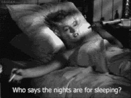 a woman is laying in bed with a cigarette in her hand and says who says the nights are for sleeping .