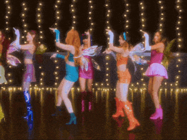 a group of girls dressed in fairy costumes are dancing
