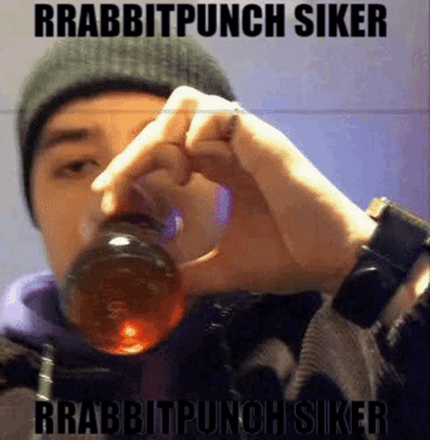 a man in a beanie is drinking from a bottle that says rabbitpunch siker