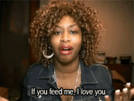 a woman with curly hair is saying " if you feed me i love you "