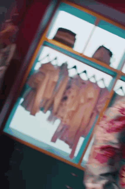 a woman is standing in front of a closet with clothes hanging on a rack