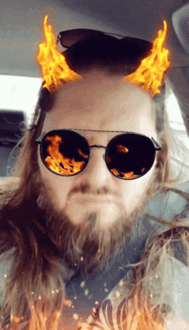 a man with a beard wearing sunglasses with flames coming out of them