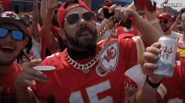 a man wearing a kansas city chiefs jersey is holding a can of bud light