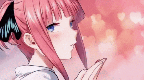 a girl with pink hair is blowing a kiss with her hand .