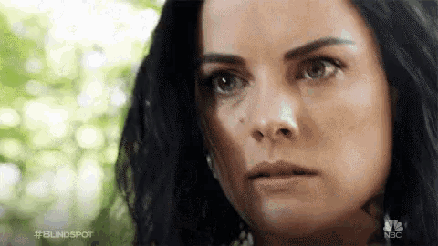 a close up of a woman 's face with a serious expression .