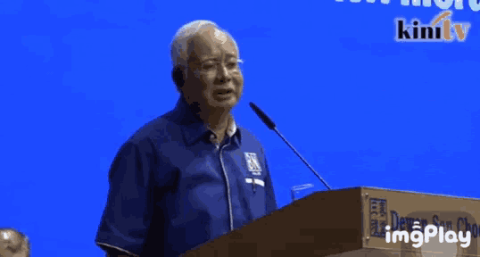 a man stands at a podium with the words " kepala bapa engkau " on the screen