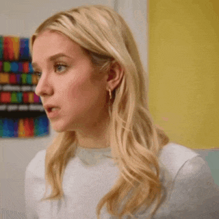 a woman with blonde hair is standing in front of a poster that says " equality "