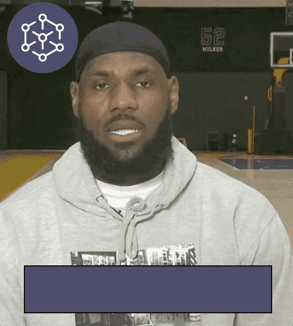 a man wearing a grey hoodie with the number 52 on the back
