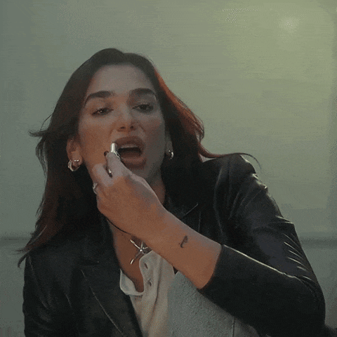 a woman in a black leather jacket has a tattoo on her wrist that says l
