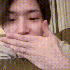 a man with a ring on his finger covering his mouth