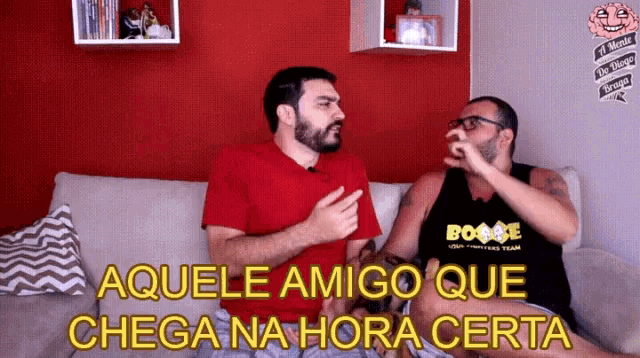 two men are sitting on a couch and one of them is wearing a shirt that says boogie