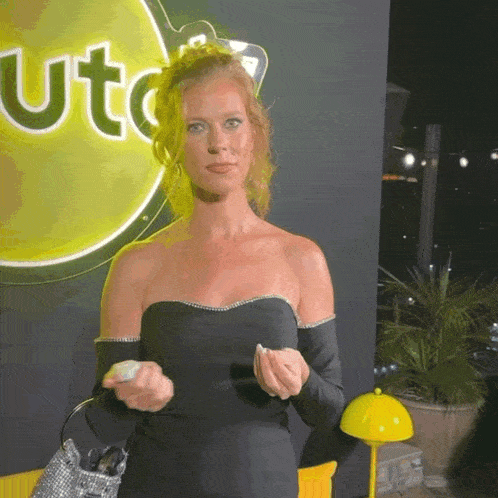 a woman in a black dress is standing in front of a sign that says ute