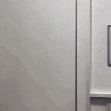 a man is peeking out of a door with a sign on the wall that says ' elevator ' on it