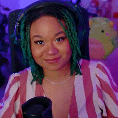 a woman with green dreadlocks is sitting in front of a microphone wearing headphones .