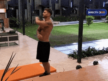 a shirtless man is standing in front of a sign that says directv