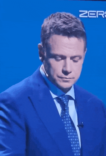 a man in a blue suit and tie with the word zero on the bottom right