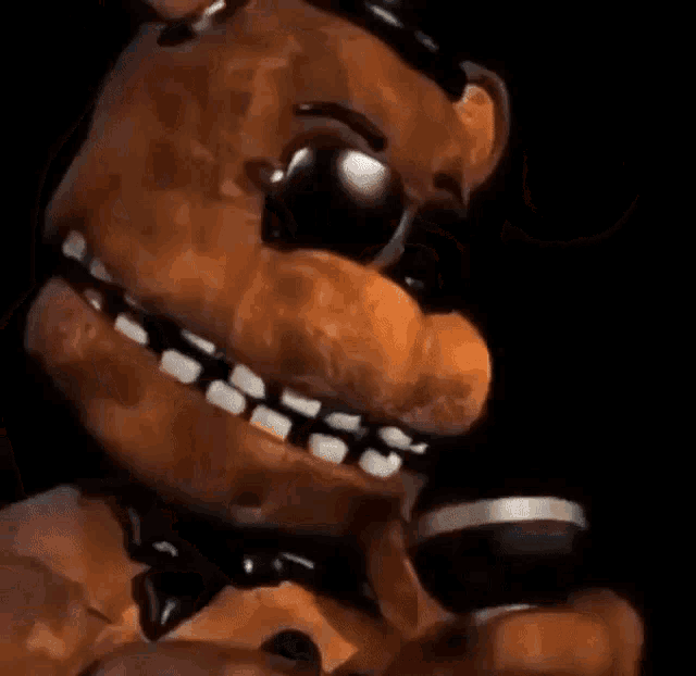a close up of a brown teddy bear wearing sunglasses and a microphone .