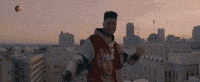 a man is standing on top of a roof overlooking a city .