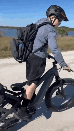 a person wearing a helmet is riding an electric bike
