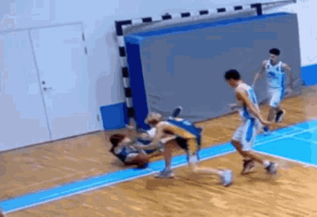 a group of basketball players are playing a game of basketball on a court
