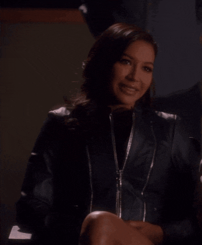a woman wearing a black leather jacket is sitting next to another woman