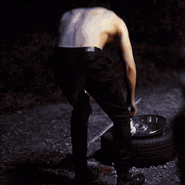a shirtless man is standing next to a motorcycle with his arms outstretched