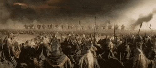 a large group of soldiers are standing in a field holding spears .