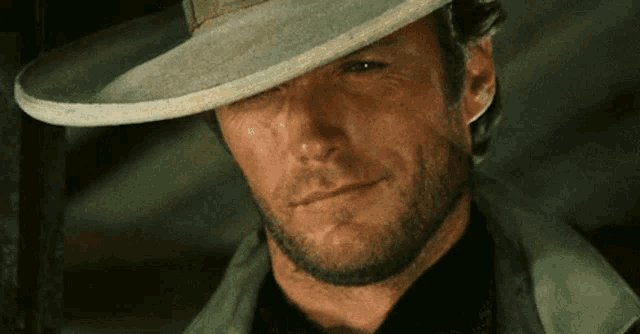 a man with a beard wearing a hat and a black shirt