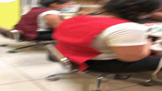 a blurry picture of a woman in a red dress sitting in a chair