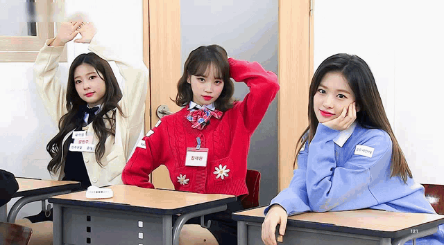 three girls are posing for a picture in a classroom with one wearing a name tag that says ' amanda ' on it