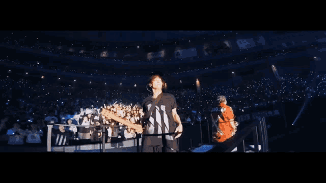 a man in a black and white shirt with the letter n on it stands in front of a crowd