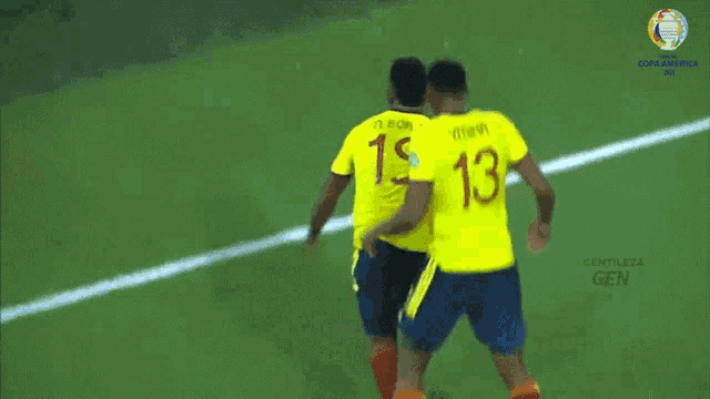 two soccer players wearing yellow jerseys with the number 13 on the back