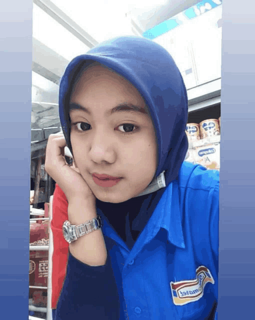 a woman wearing a blue shirt with a sticker that says indomaret