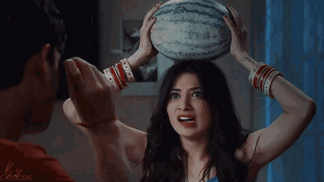 a woman holding a watermelon on her head with kin creations written in the corner