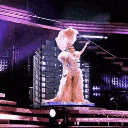a statue of a woman in a fancy dress holding a fan on a stage