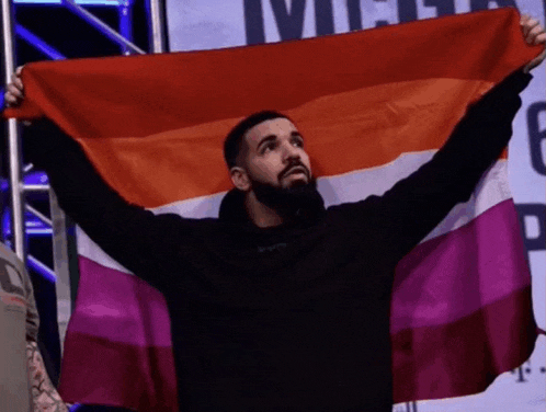 a man is holding a rainbow flag in his hands