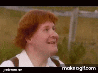 a man with red hair and missing teeth is smiling in a video .
