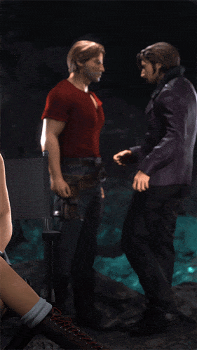 a man in a suit and a man in a red shirt are kissing in a dark room