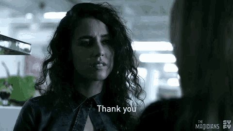 a woman with curly hair is talking to another woman and saying thank you .