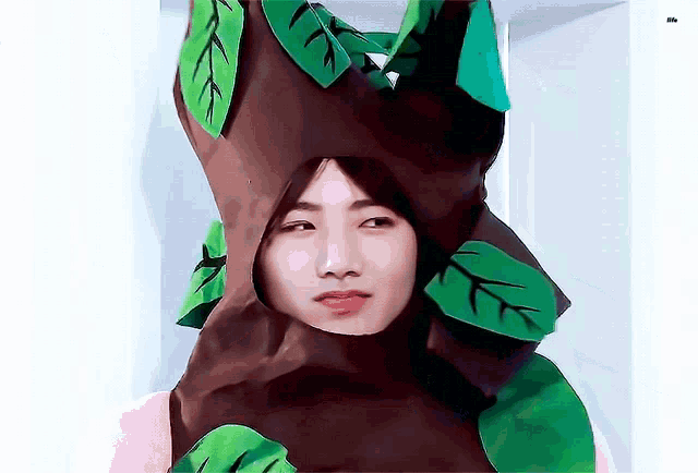 a person in a tree costume with green leaves on it