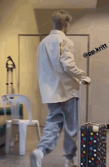 a man walking with a suitcase with the name pp.kritt on the bottom