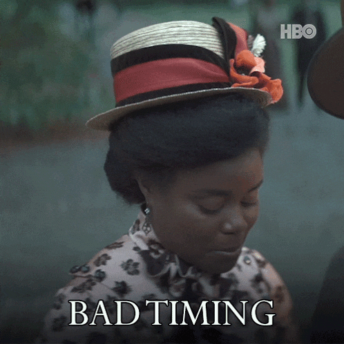 a woman wearing a straw hat is smiling with the words bad timing above her