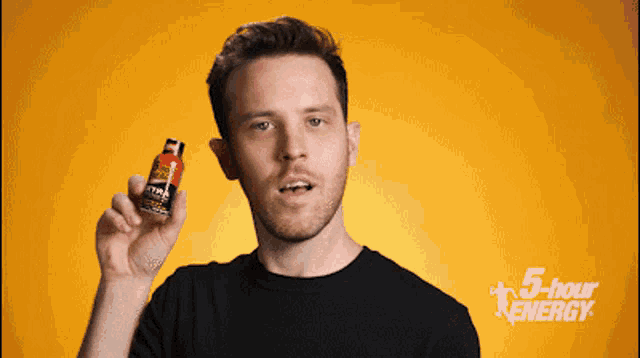 a man is holding up a bottle of 5 hour energy drink