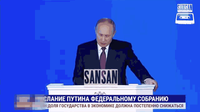 a man stands at a podium with sansan written on it