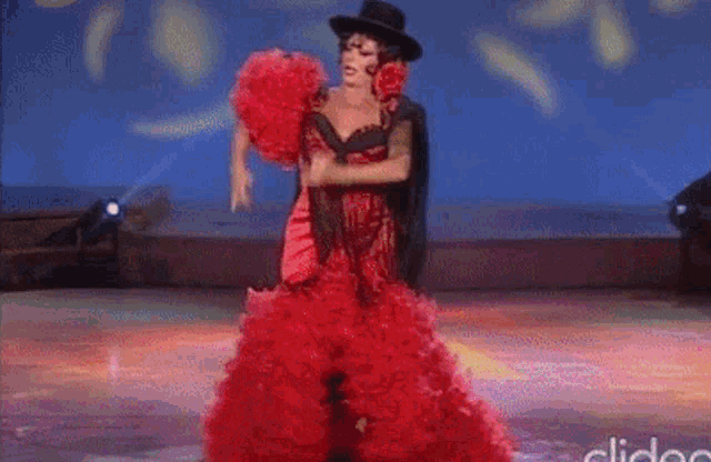 a woman in a red dress is singing into a microphone on a stage