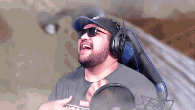 a man with a beard wearing headphones and sunglasses laughs